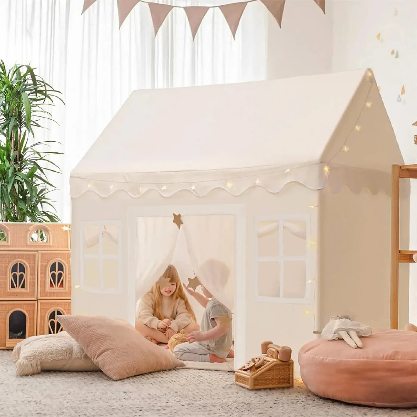 Tiny Land cream playhouse tent with windows and string lights in a child's room