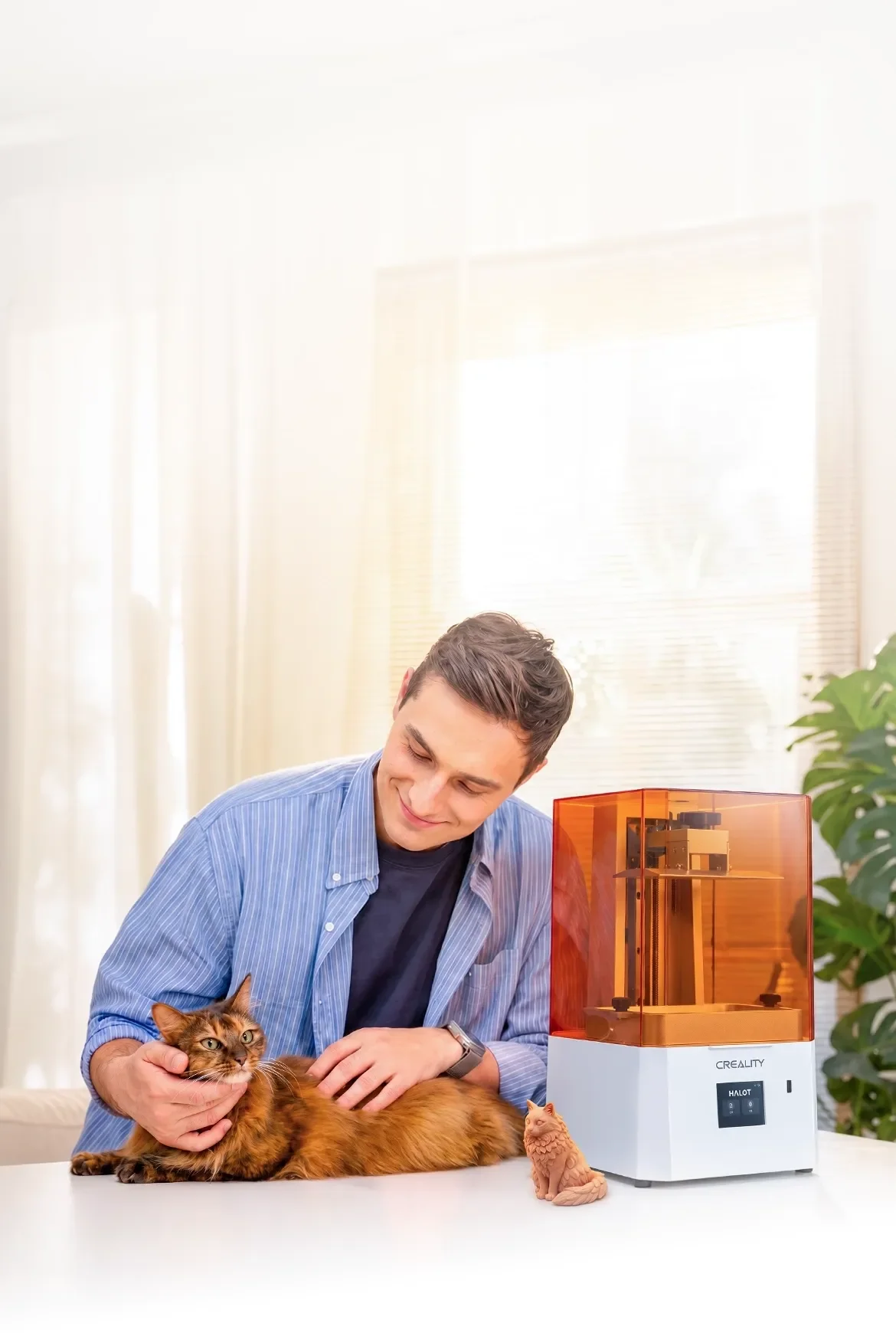 Person with a cat beside a Creality HALOT-X1 Neo orange resin 3D printer