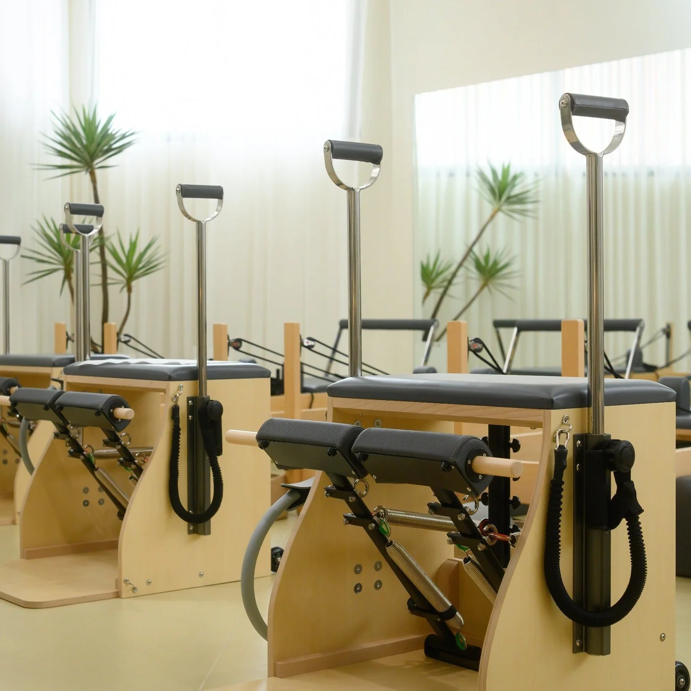 PersonalHour maple wood Pilates chairs with handles in a bright studio